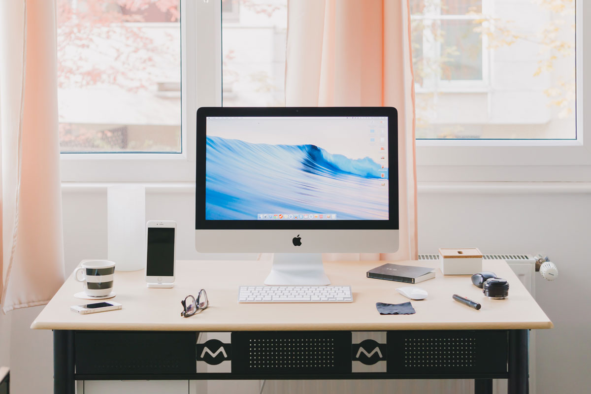 Mac computer with a high converting website on screen sitting on top of a clean desk in a bedroom