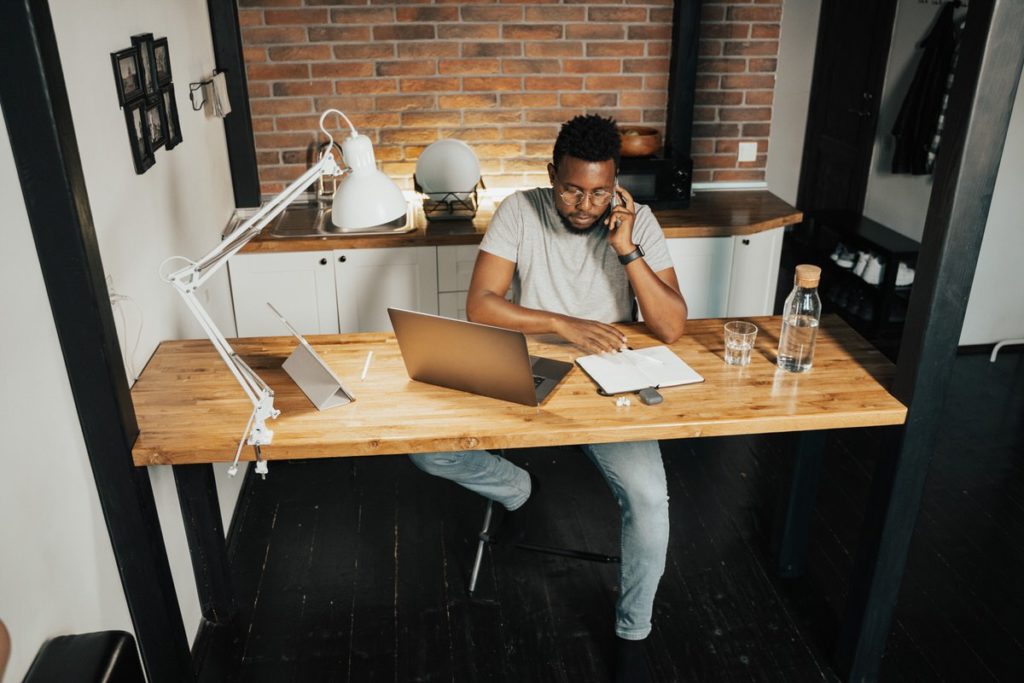 Man working at a desk while on a phone