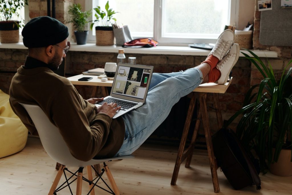 Man sitting on a chair with his legs up while working on the computer