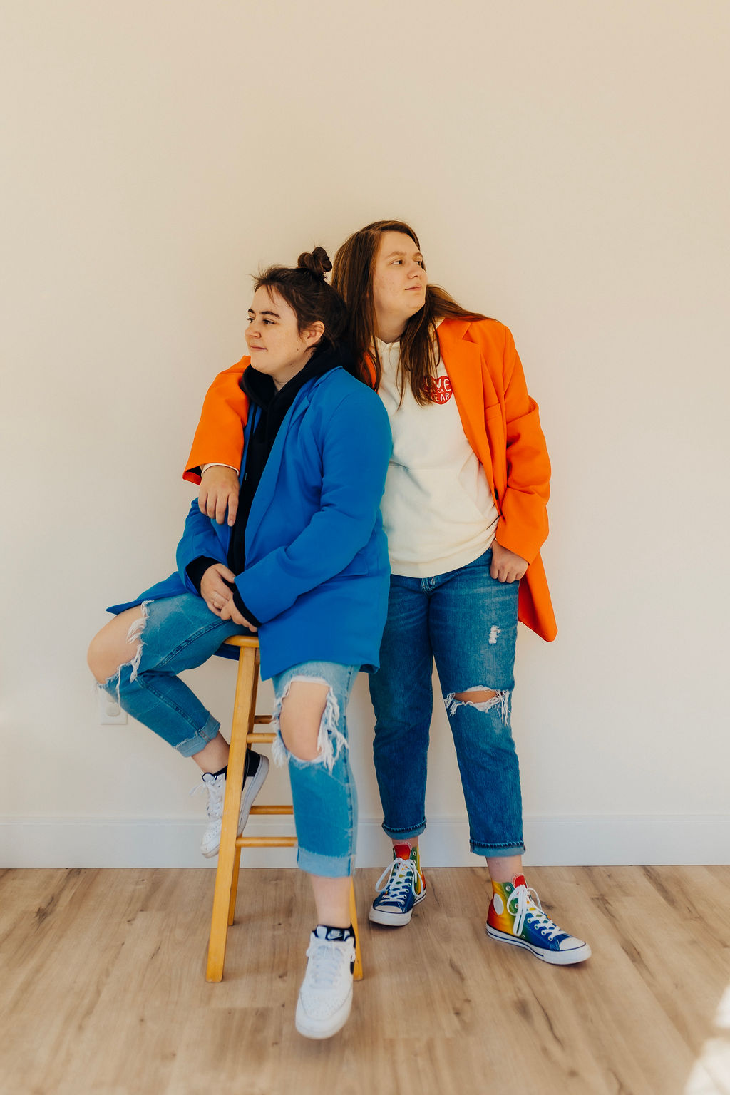 Two girls in jeans and blazers look opposite directions in the featured image for websites for creatives.