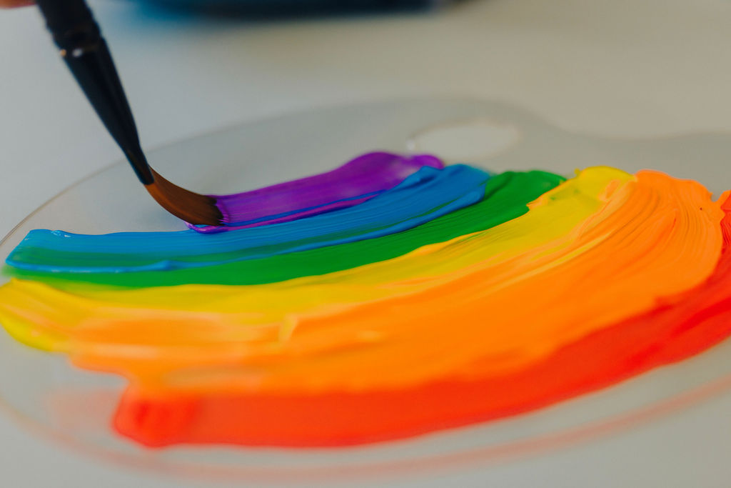final color of the rainbow being painted onto a clear paint palette 