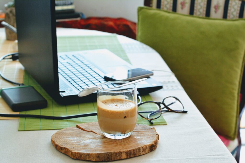 A laptop sits open next to a cup of coffee.