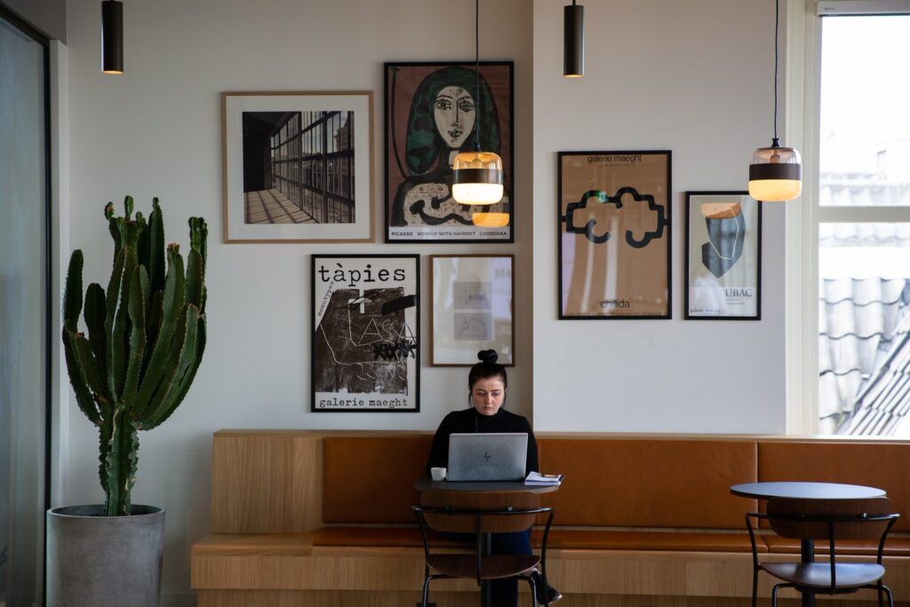 A woman sits in a cafe working on a computer.