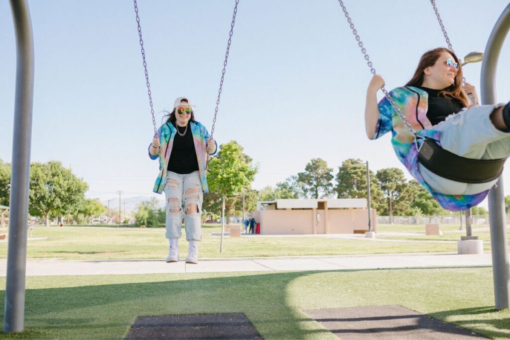 Two girls swinging on swings.