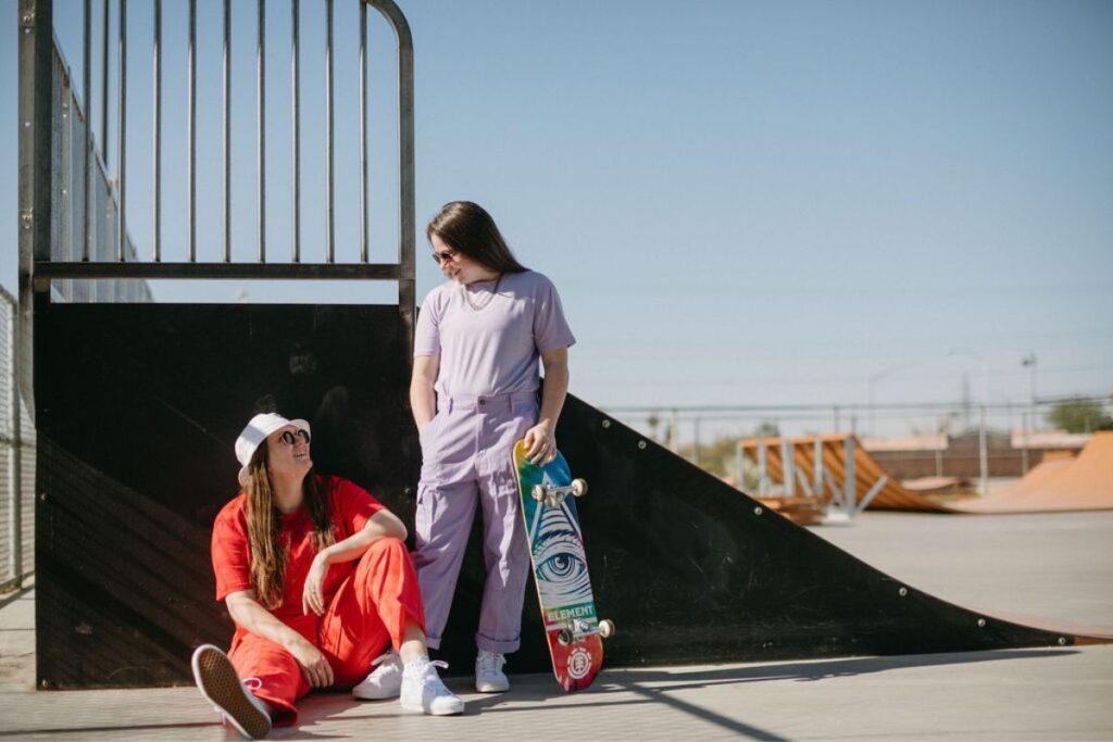 Two girls next to a ramp at a skate park.