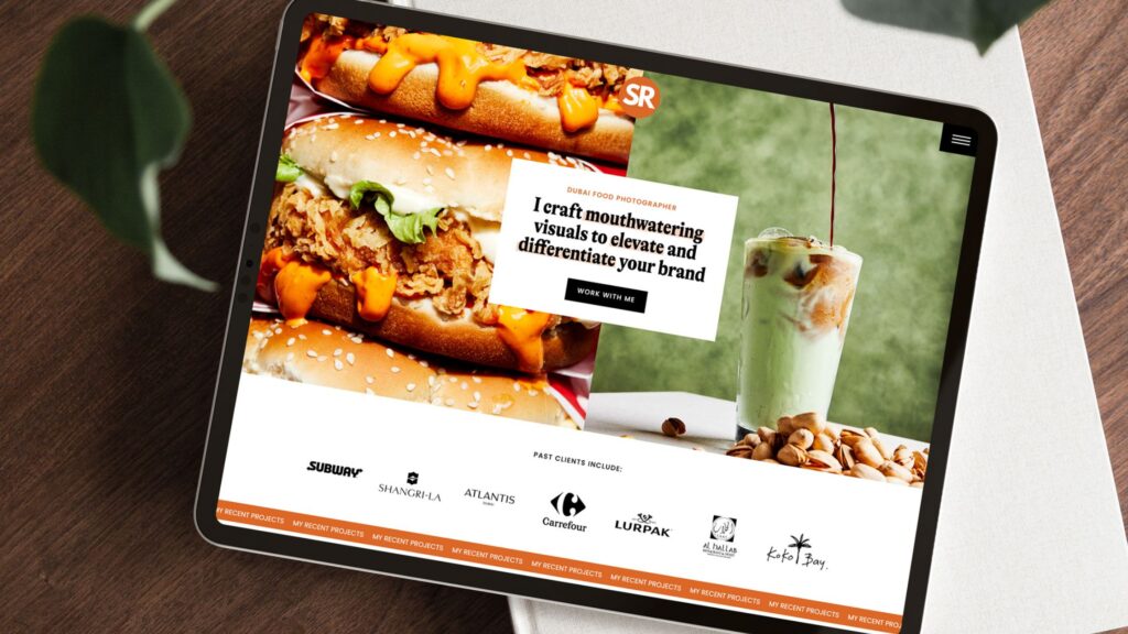 An iPad with a food photographer's website pulled up, sitting on a book on a coffee table. 
