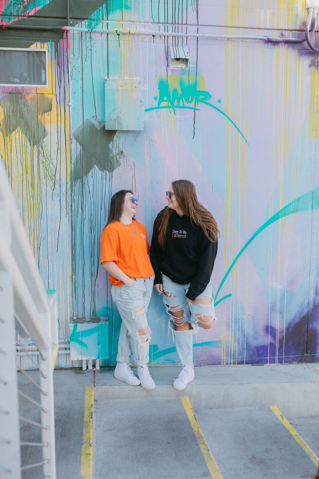 Featured image for good vs bad feedback with two women standing together against a splatter painted wall.