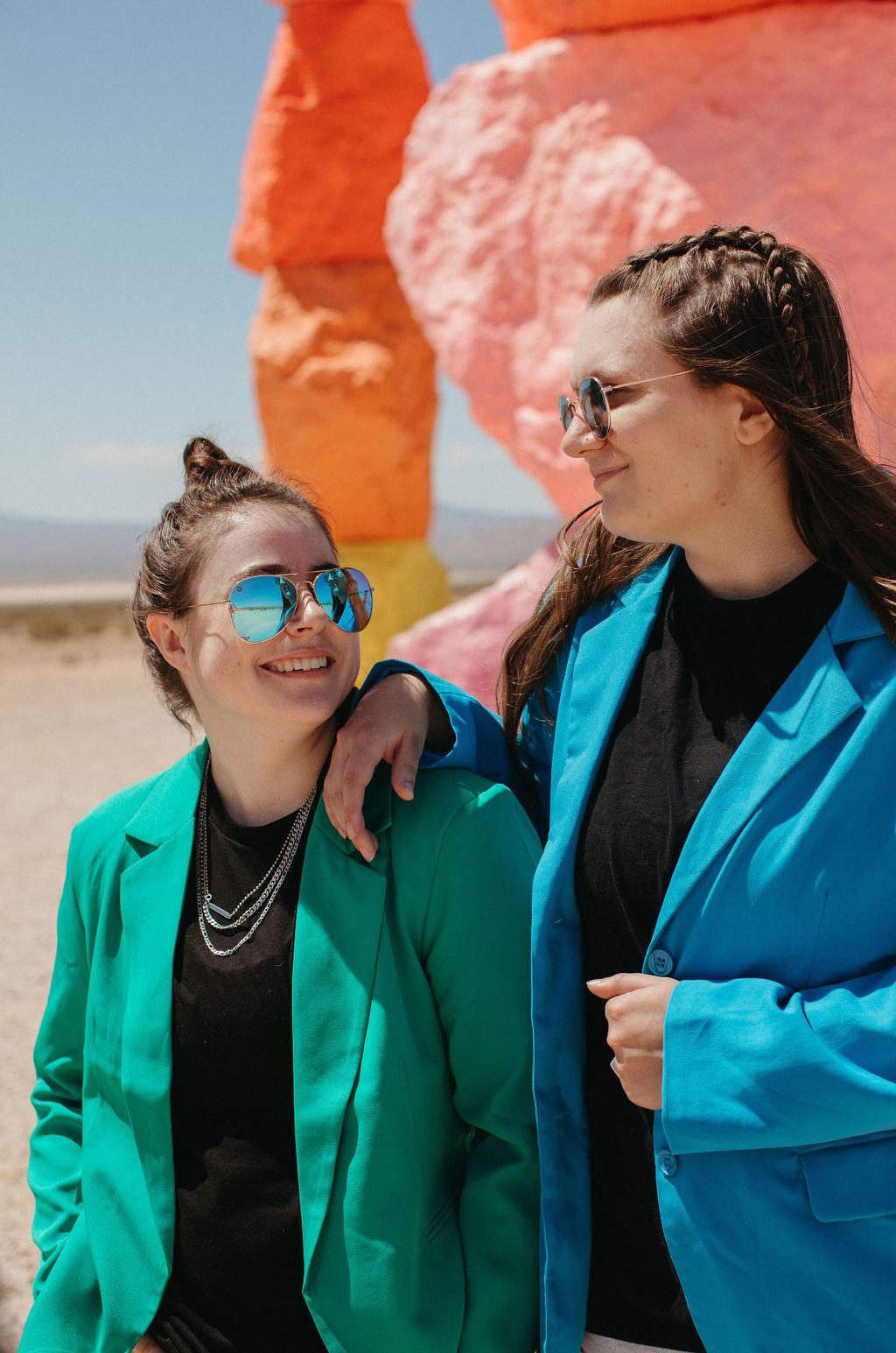 Two individuals in colorful attire with a vibrant, sculptural background, visually representing the dynamic and personalized approach in therapist website design