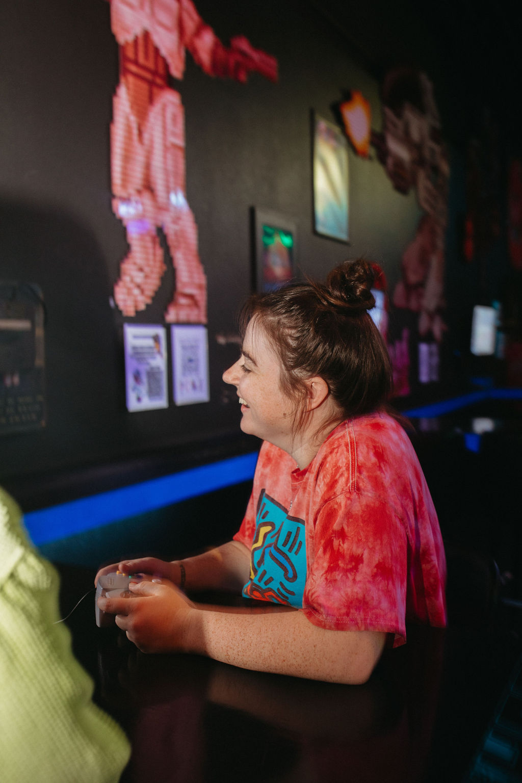 Girl smiling in a red shirt while playing a video game. Featured image for ideal photography client blog post.