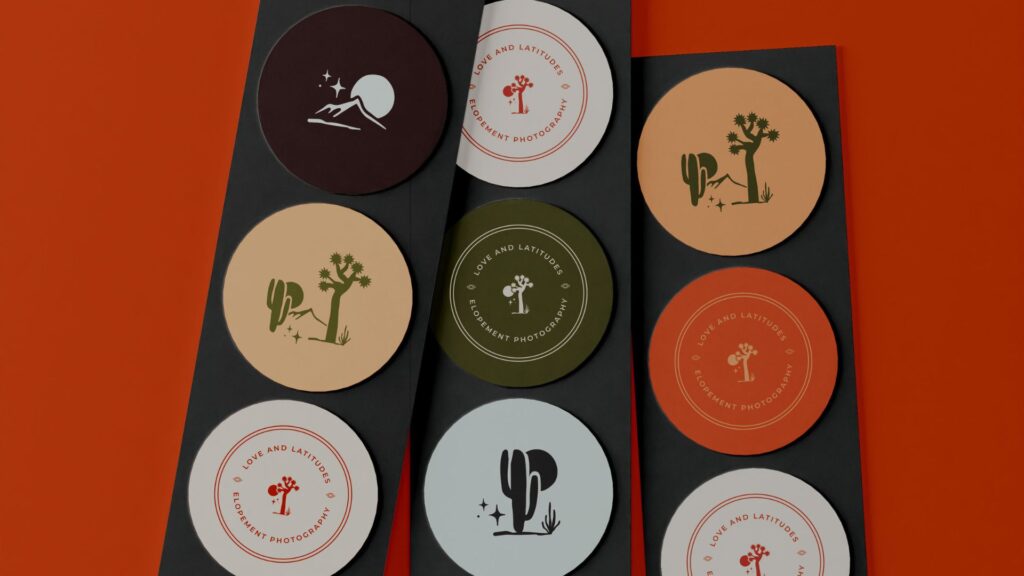A collection of circular coasters with 'Love and Latitudes Elopement Photography' branding, featuring designs with desert landscapes, cacti, and a couple under the stars, set against an orange and dark gray background.
