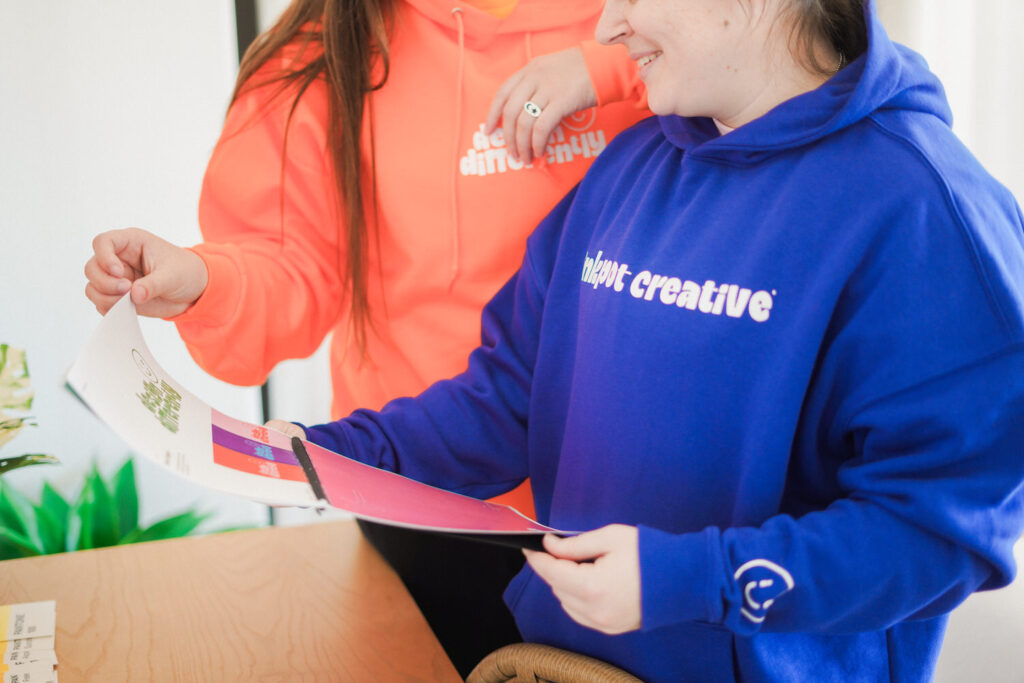 KP and Jessie look through a printed booklet.