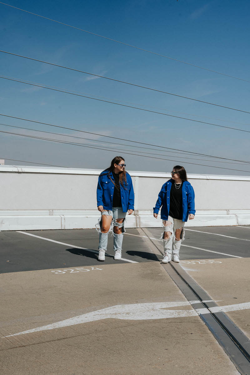 Two people walking together in a parking lot