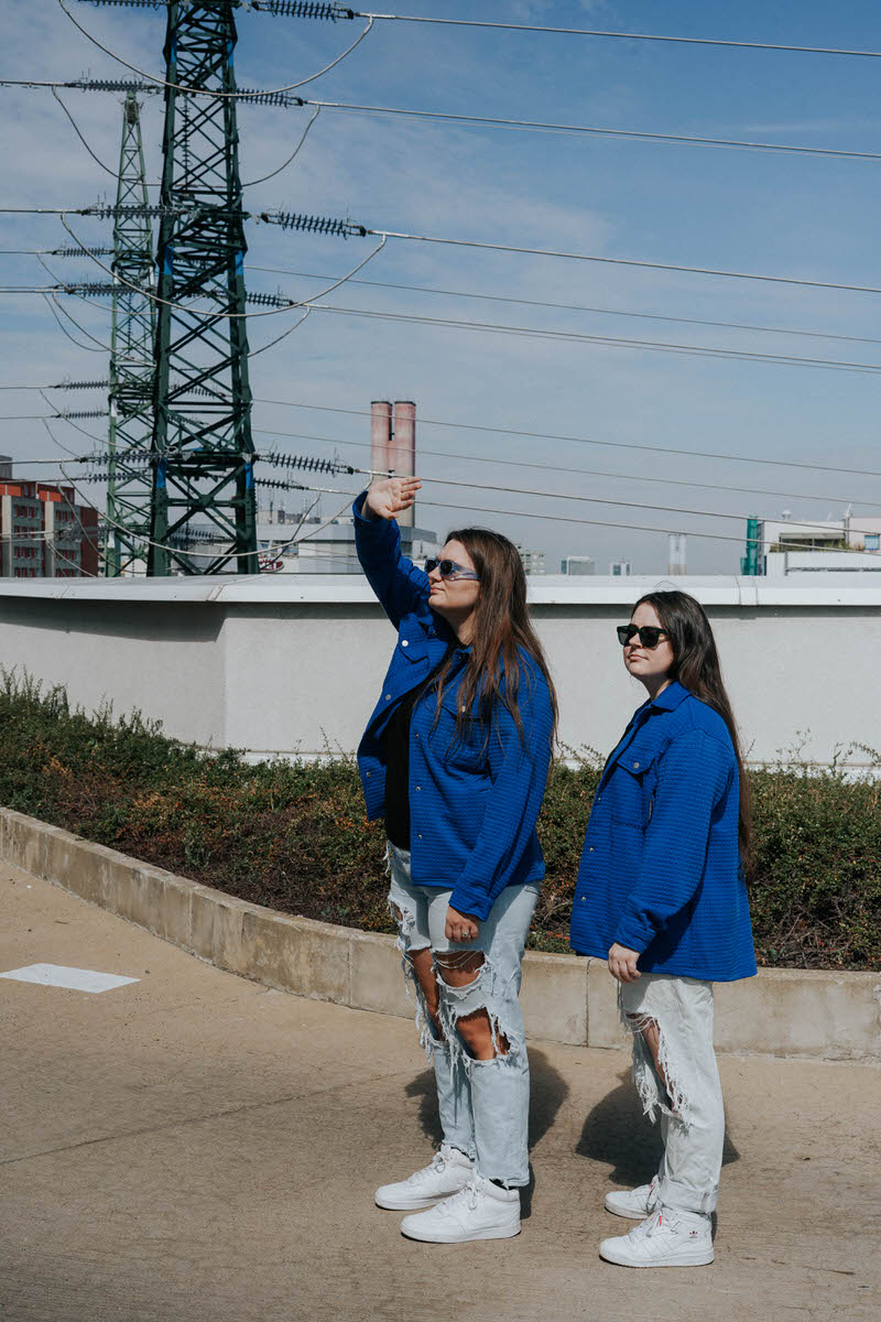 Two people standing together while one puts their hand up in the air