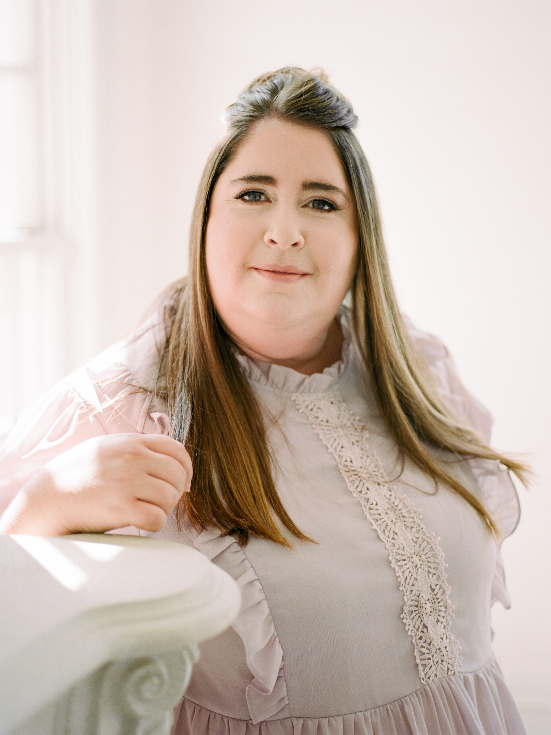 A woman sitting in a chair with a slight smile on her face