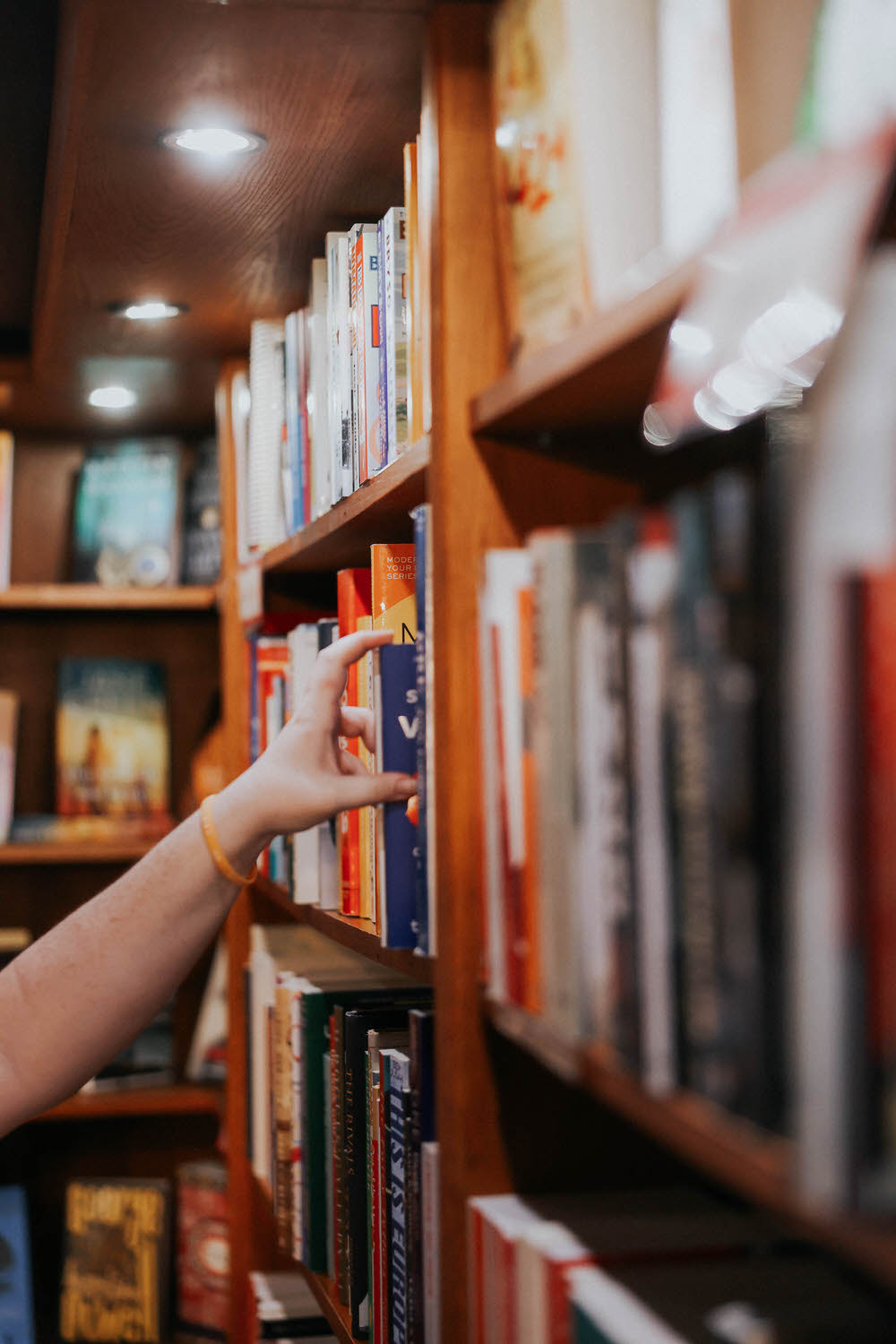 Jessie reaches for a book on the shelf.