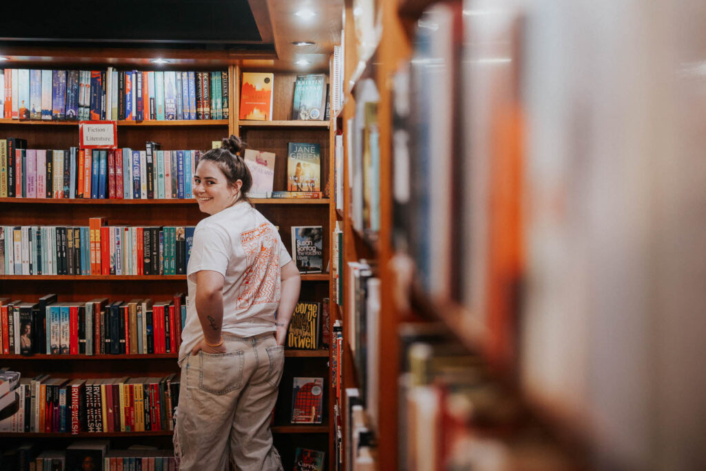 Jessie looks back at the camera in a bookstore.