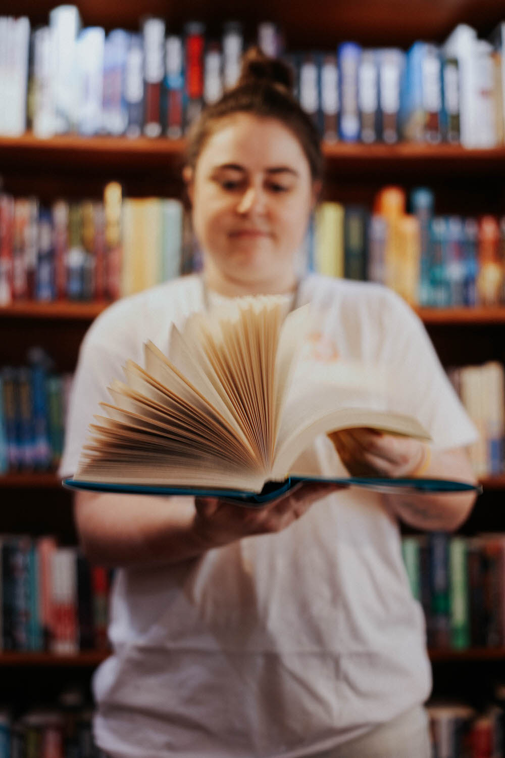 Woman flipping open a book in a bookstore.