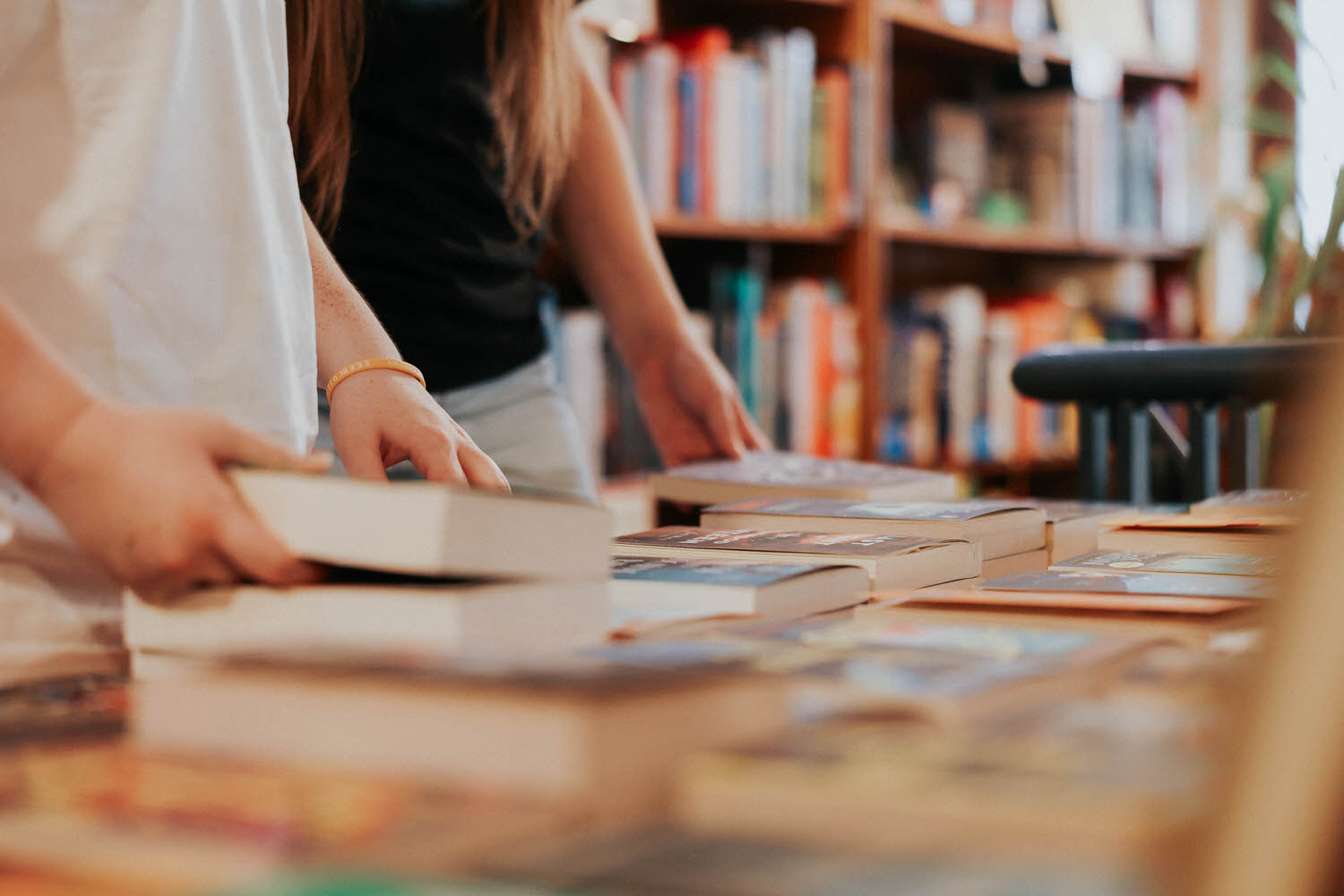 Close up of KP and Jessie picking up books.