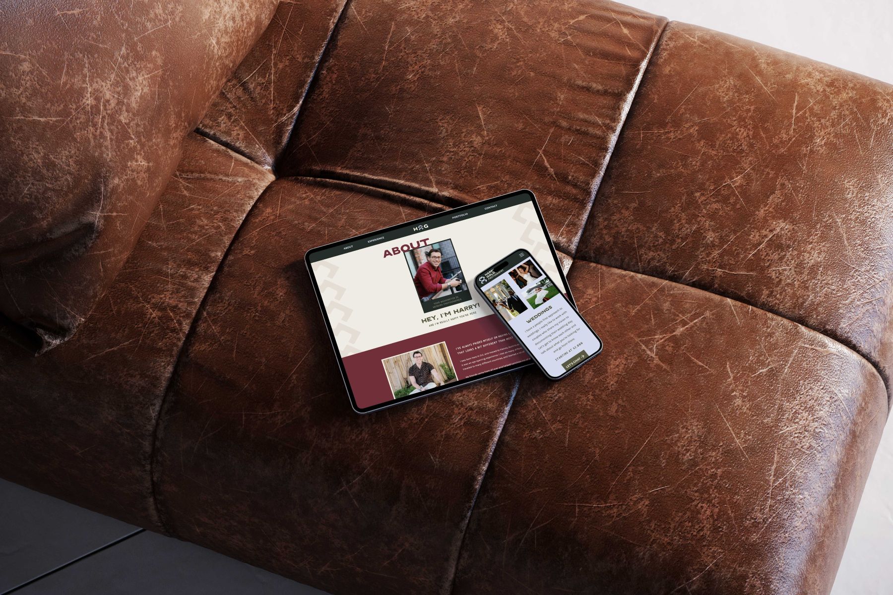 a mobile phone and table displaying harry goldman photography's website both are set on top of a leather couch