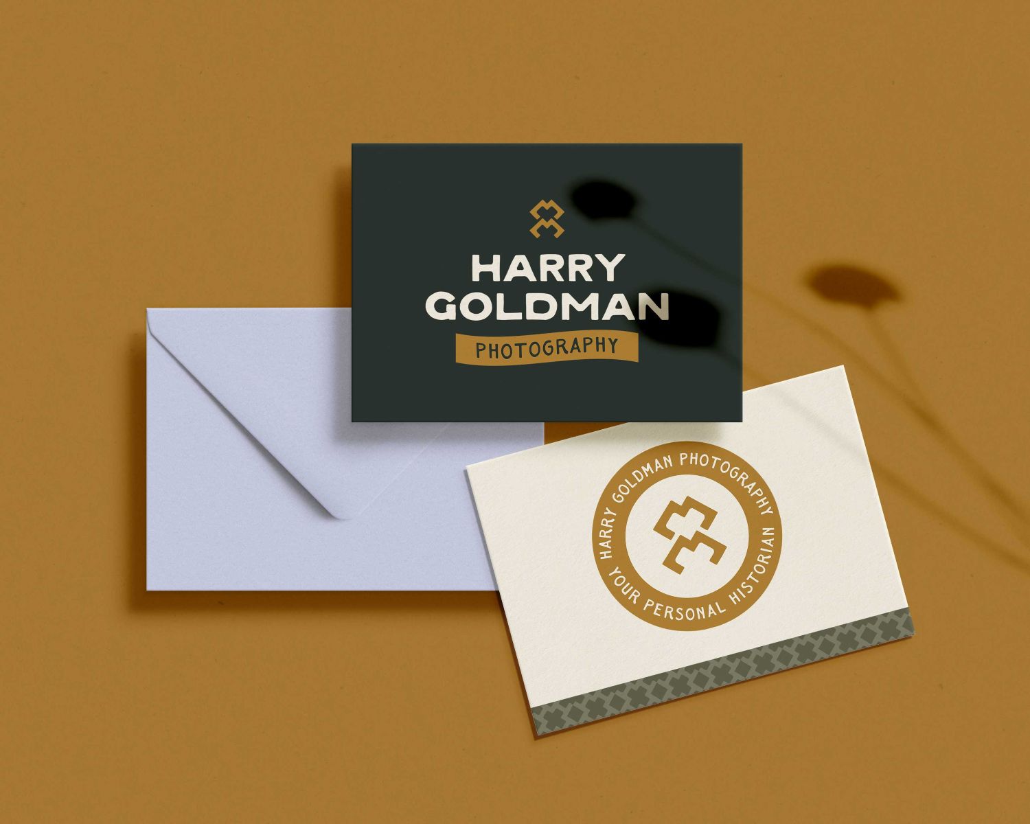 business cards for harry goldman photography set against a brown backdrop