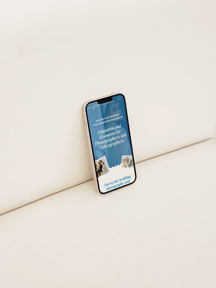 a mobile phone displaying the combs creative website set against a white backdrop