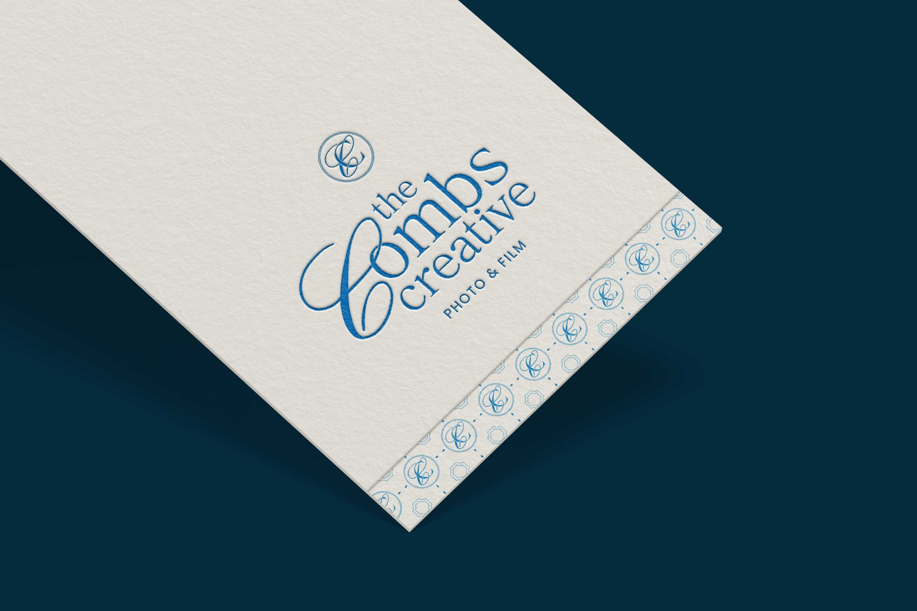 an elegant business card for The Combs Creative set against a navy blue backdrop