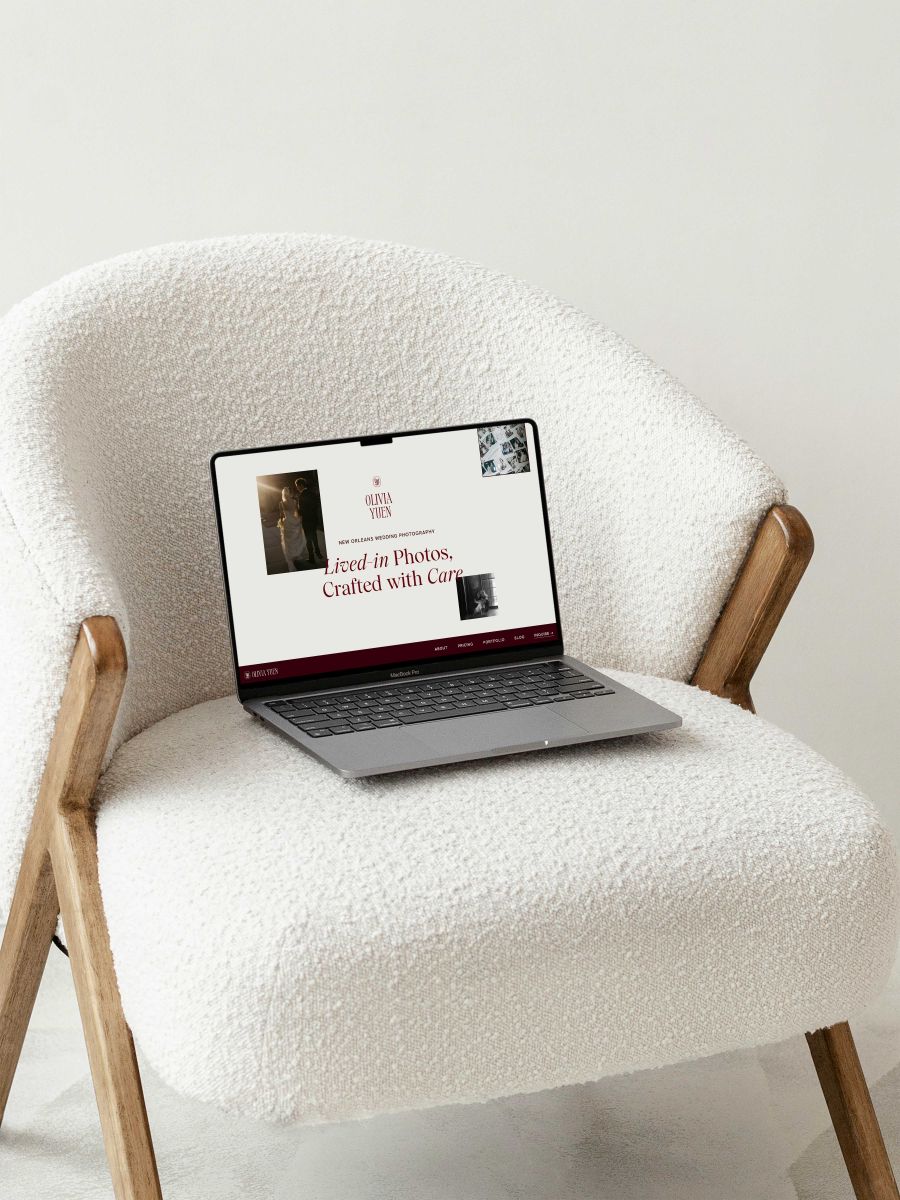 a laptop with olivia's yuen photography's website dispalyed the laptop is on top of a white chair