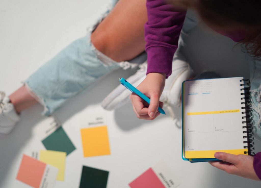 A person writes in a planner.
