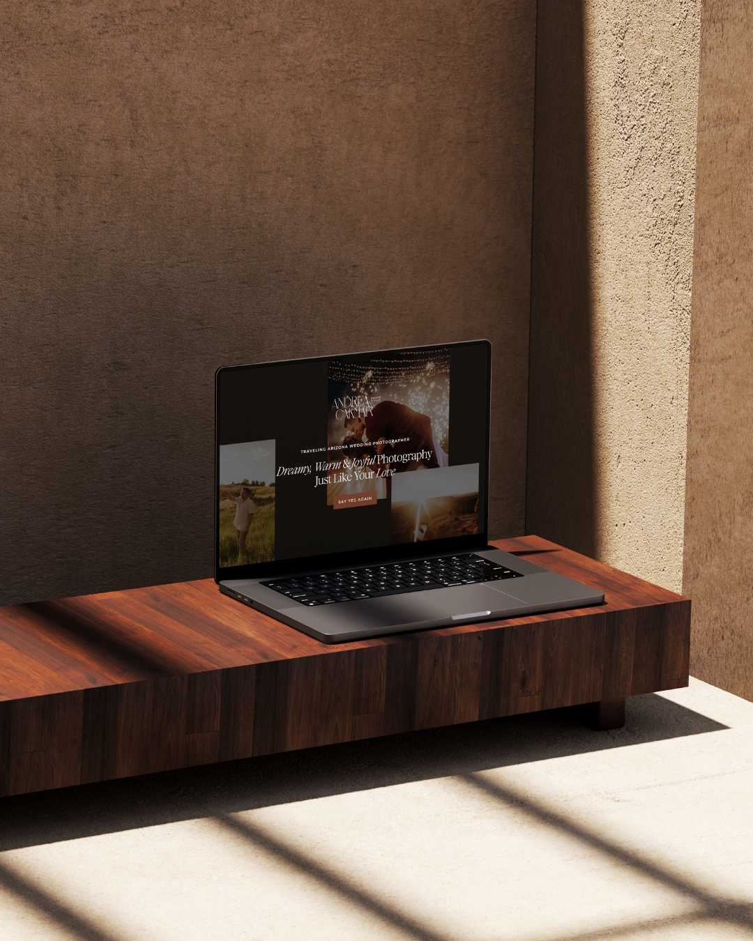 andrea camara photo and film's website displayed on a laptop on top of wooden bench