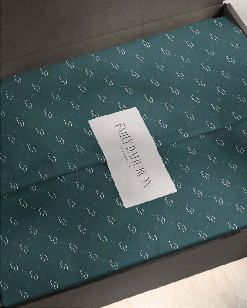 a box with wrapping paper and a sticker from emily dahuron photography