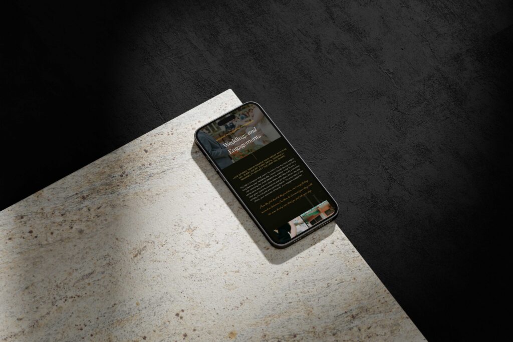 a mobile phone on top of a marble countertop displaying the website for tori k visuals