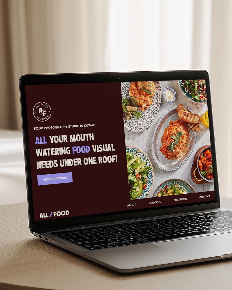 a laptop on top of a table displaying the website for all foods 
