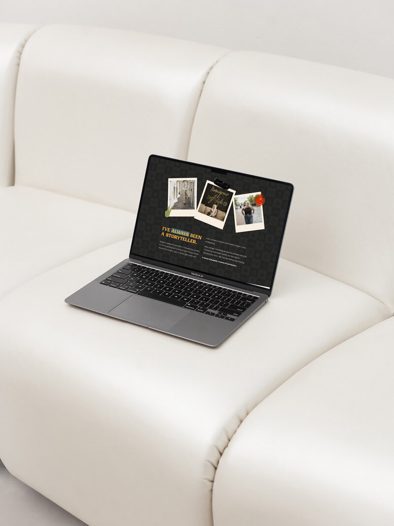 a laptop displaying the website for Amanda Macchia Photography resting on top of a white sofa 