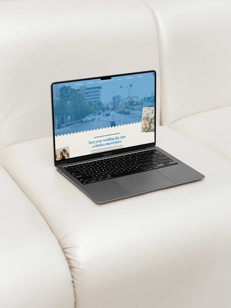 a laptop on a white couch the laptop is displaying the website for the combs creative 