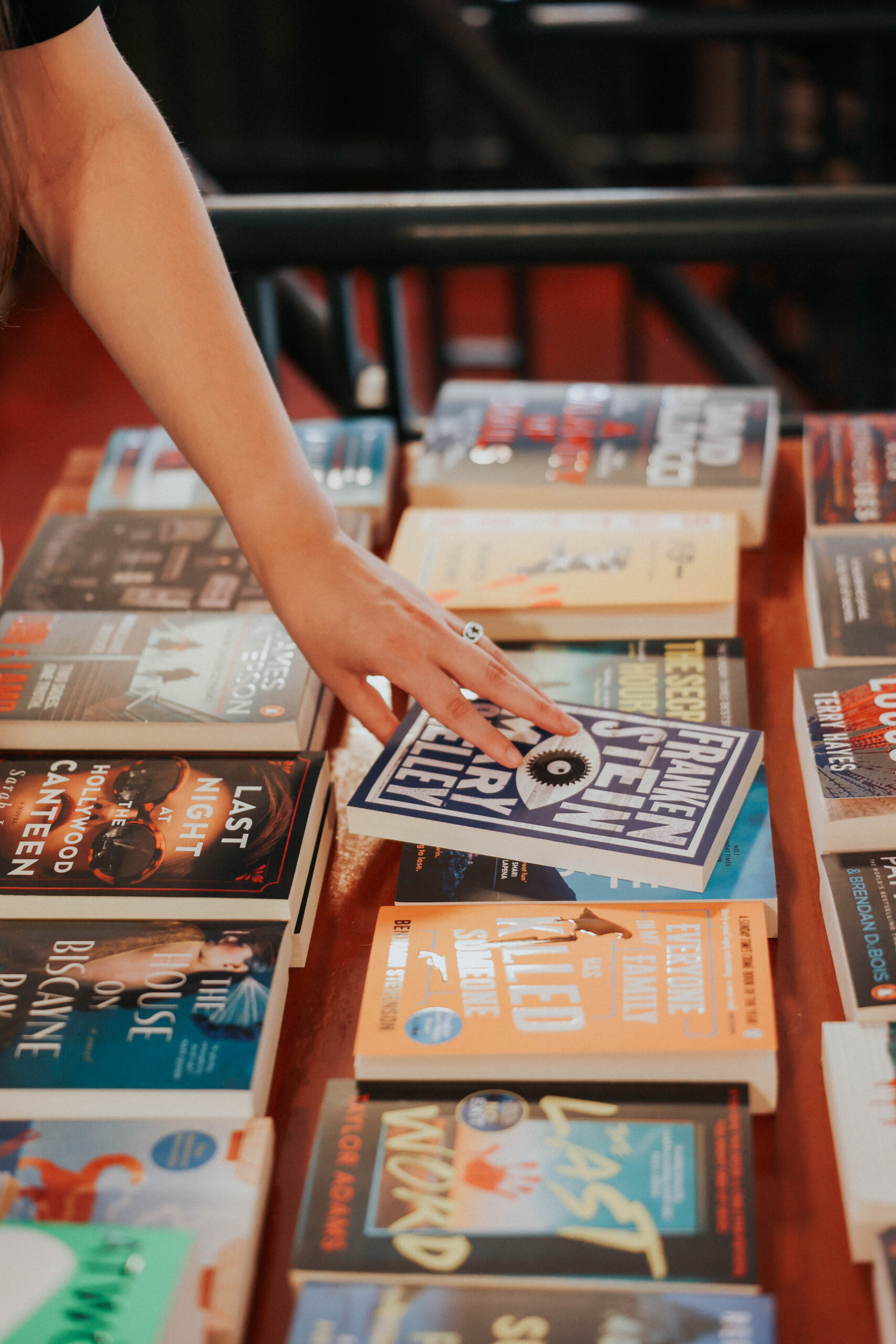 a person touching books on a table in a bookstore 